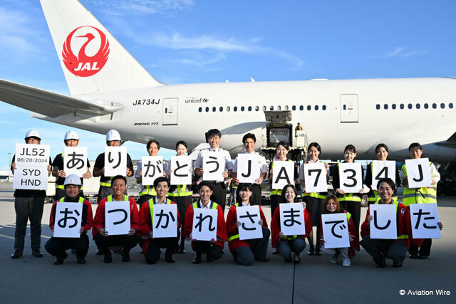 羽田空港に到着したJAL初の777-300ER退役機となったJA734Jによるシドニー発JL52便をパネルを手に出迎えた社員ら＝24年8月20日 PHOTO: Tadayuki YOSHIKAWA/Aviation Wire