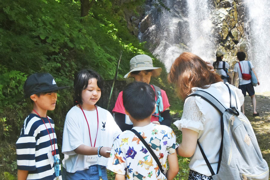 不動滝前のゴールで参加者を迎える児童