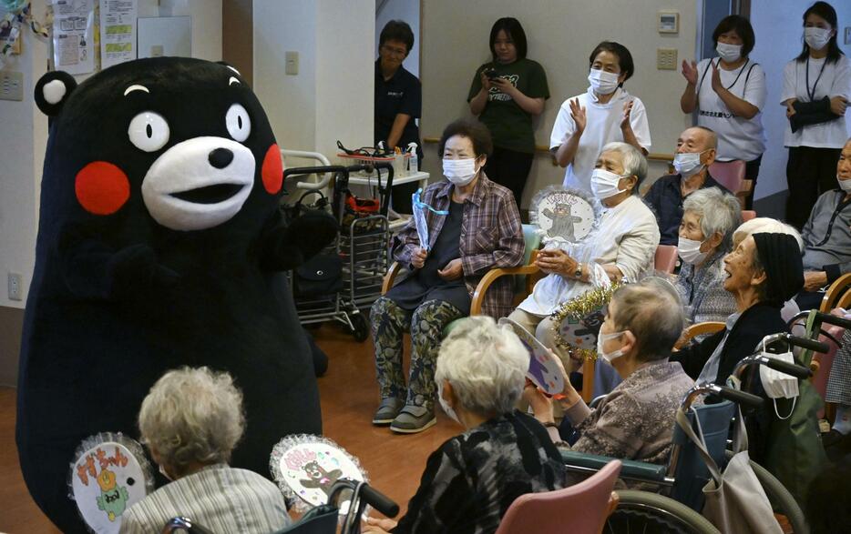 石川県珠洲市のデイサービス施設を訪れた「くまモン」。右端は中平ひふみさん＝6日午後