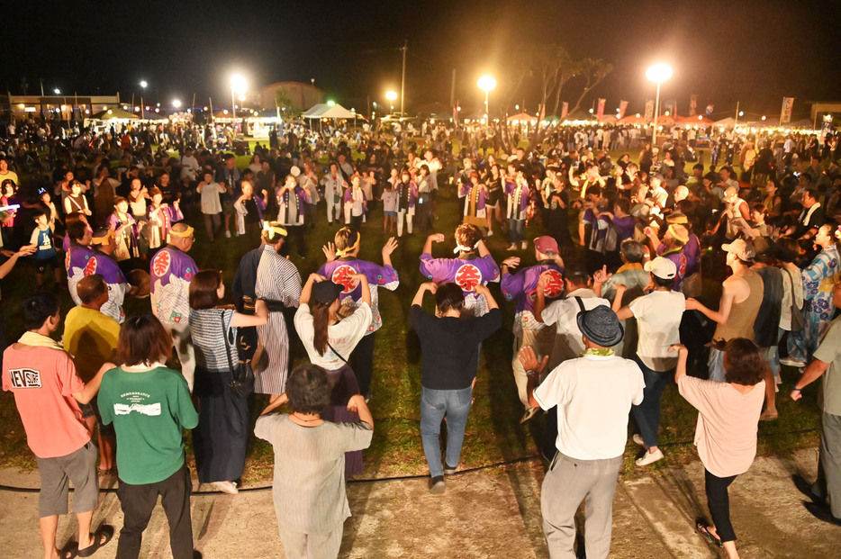 西仲間集落の八月踊りで、大きな輪をつくり舞う参加者たち＝25日、鹿児島県奄美市住用町