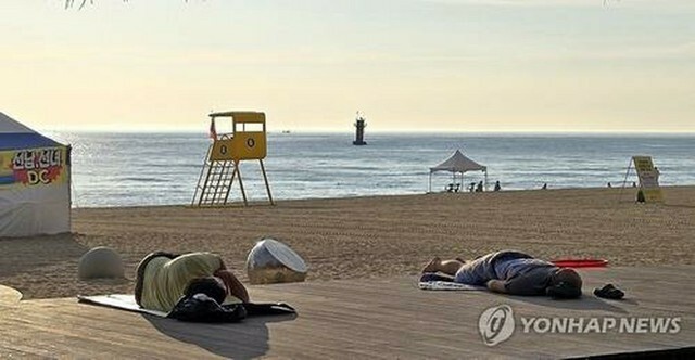 北東部・江陵の鏡浦海水浴場。熱帯夜を避けて海辺で涼を取る住民＝7日、江陵（聯合ニュース）