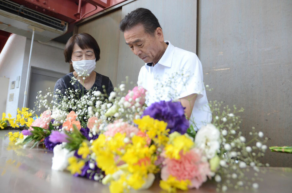 客用の花束を作る松島さん夫婦。「地域の人に支えられ、商売を続けられた」＝8月下旬、浜松市浜名区の花大