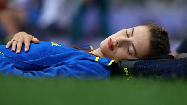 競技場で眠る陸上女子走り高跳びのヤロスラワ・マフチフ選手(写真：ロイター/アフロ)