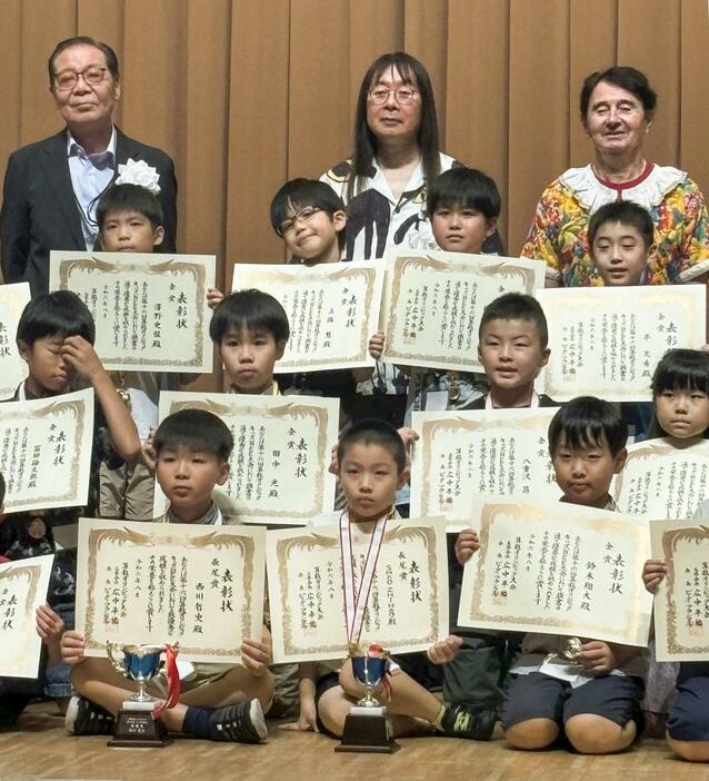 「算数オリンピック」の表彰式で記念撮影する「長尾賞」受賞の西川哲史さん（最前列左）、大会会長のピーター・フランクルさん（最後列右）ら＝18日、東京都内