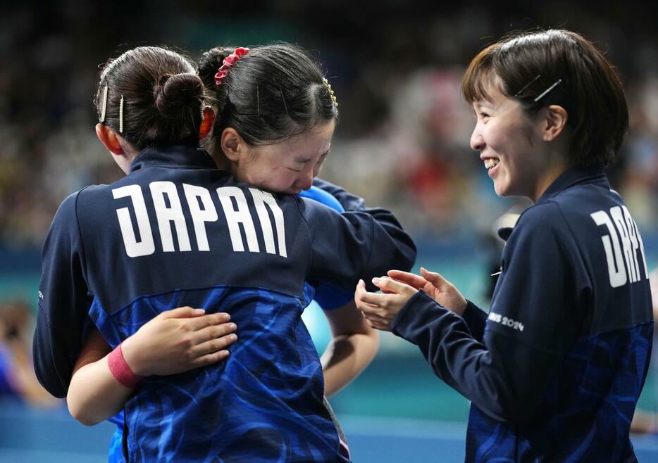 女子団体準決勝でドイツに勝利し、張本美和（中央）を迎える早田ひな（左）と平野美宇＝パリ（共同）