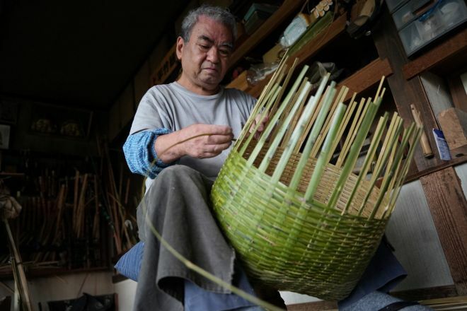 しょいかごを編む弟の上平敬さん