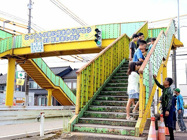 歩道橋に感謝のメッセージを書き込む住民＝南砺市福野地域