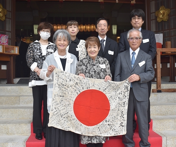 遺族の芙佐子さん（前列中央）らと日章旗の返還を喜ぶ一稔さん（同右）