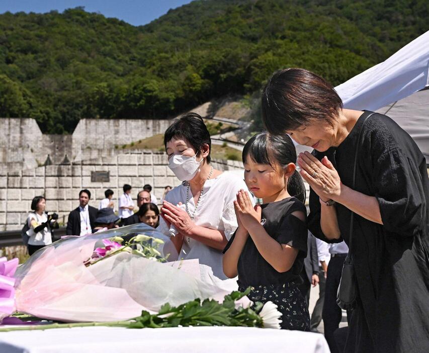 献花式で慰霊碑に手を合わせる地域住民たち（18日午前10時21分、広島市安佐南区八木3丁目）