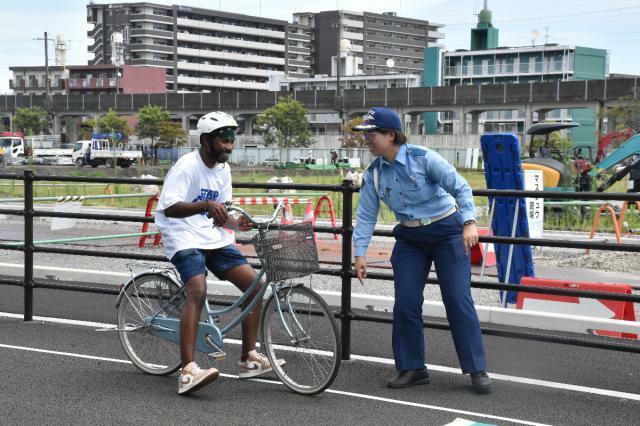 自転車に乗り、交通ルールを学ぶ外国人留学生＝２０日午前、宮崎市・宮崎北署