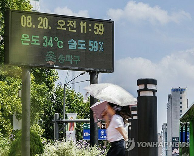 気温34度と表示されたソウル市内の電光掲示板＝20日、ソウル（聯合ニュース）