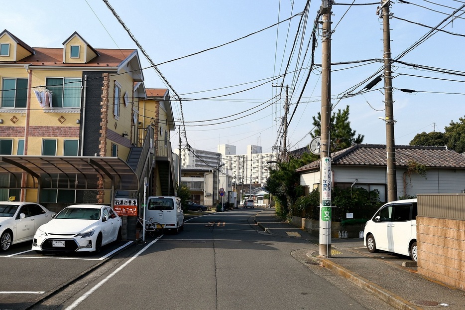 事故現場。真由さんは左の駐車場から、右側に向かって道路を横断しようとしたところ、手前から前方に進行中の軽乗用車が衝突した