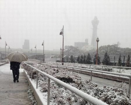 [写真]通天閣近くの道も雪が積もり始めている＝14日午前7時40分ごろ