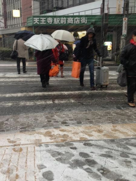 [写真]横殴りの雪の中を歩く人たち＝14日午前7時半ごろ、大阪市天王寺区で