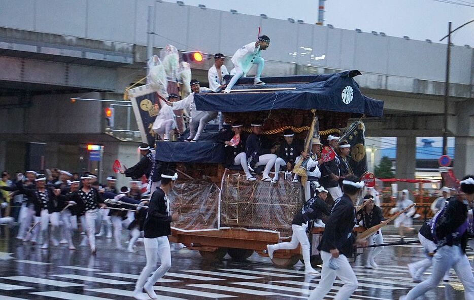 [写真]アスファルトを打ちつける激しい雨の中、やり回しを決める＝12日午前6時すぎ、大阪府岸和田市で