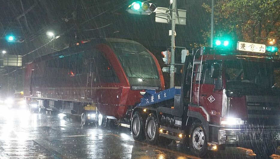 [写真]降りしきる雨の中、輸送される近鉄の新型特急「ひのとり」＝25日午前3時すぎ、大阪府八尾市で