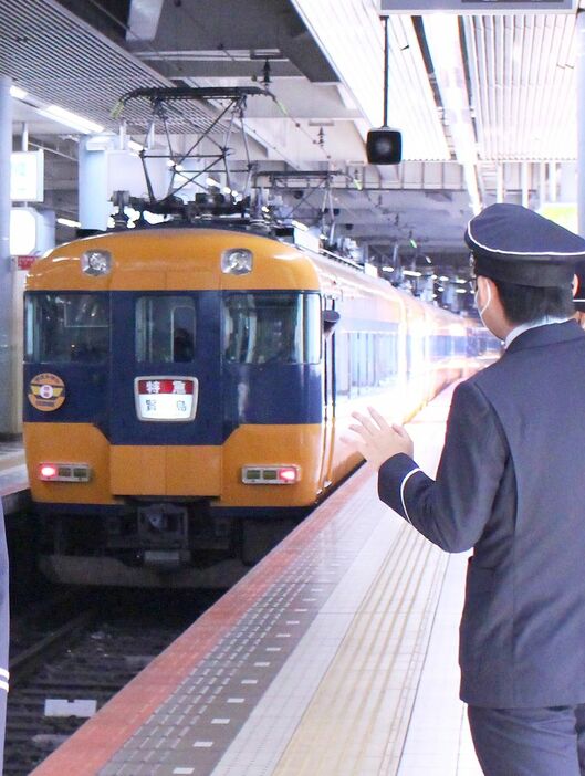 [写真]スナックカーの愛称で親しまれた近鉄12200系車両のラストランを見送る駅員ら＝20日午前、大阪市天王寺区の大阪上本町で