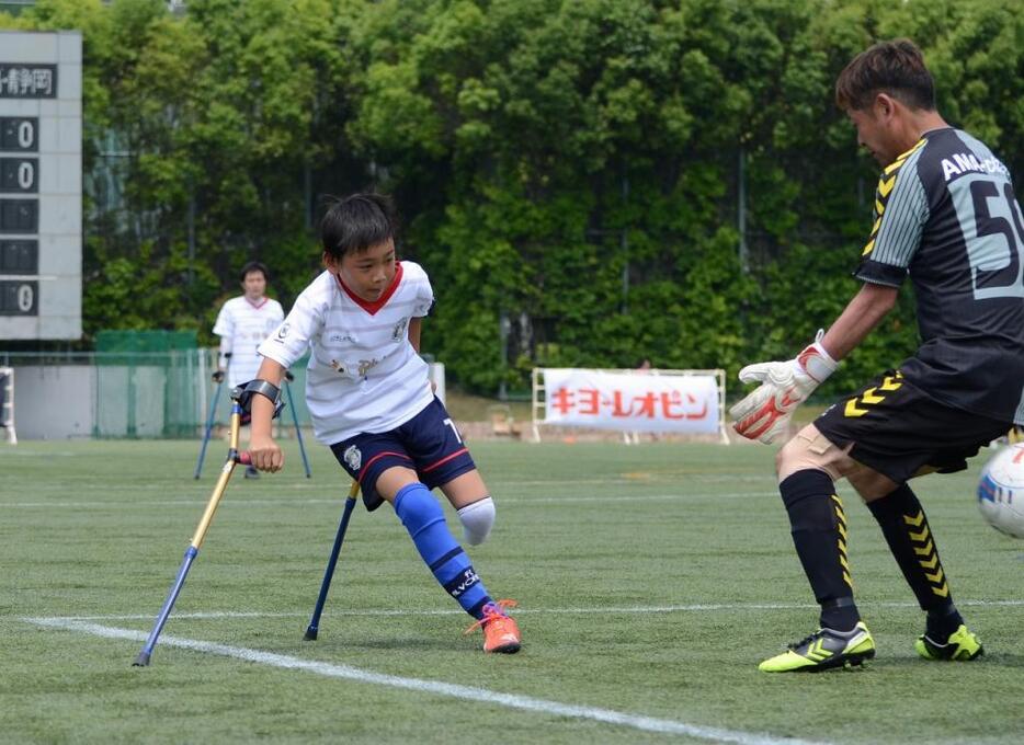 [写真]キーパーの横を抜くシュートを決める石井（左）。小学生として公式戦初得点