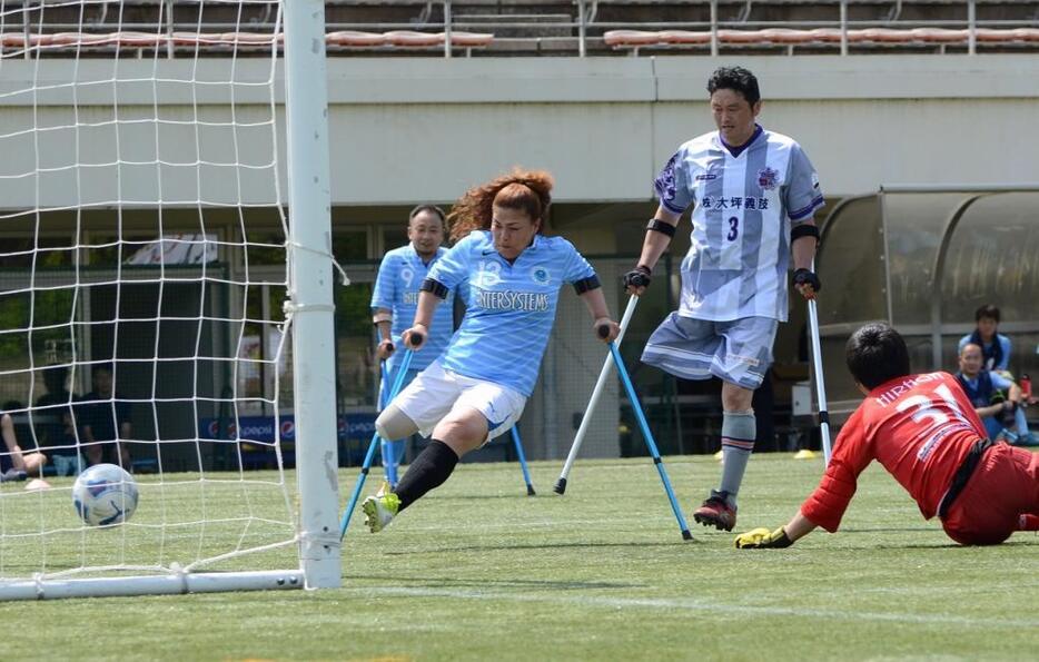 [写真]女子選手第1号としてのデビュー戦で、ゴールを決める秋田（左）