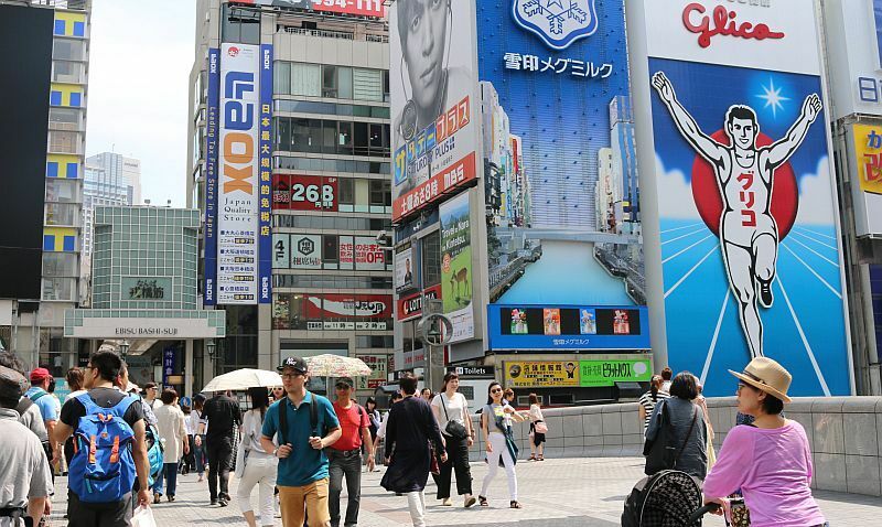 [写真]道頓堀の戎橋ではサングラスに帽子、日傘を使った観光客らでにぎわいをみせていた=23日午後2時すぎ、大阪市中央区で