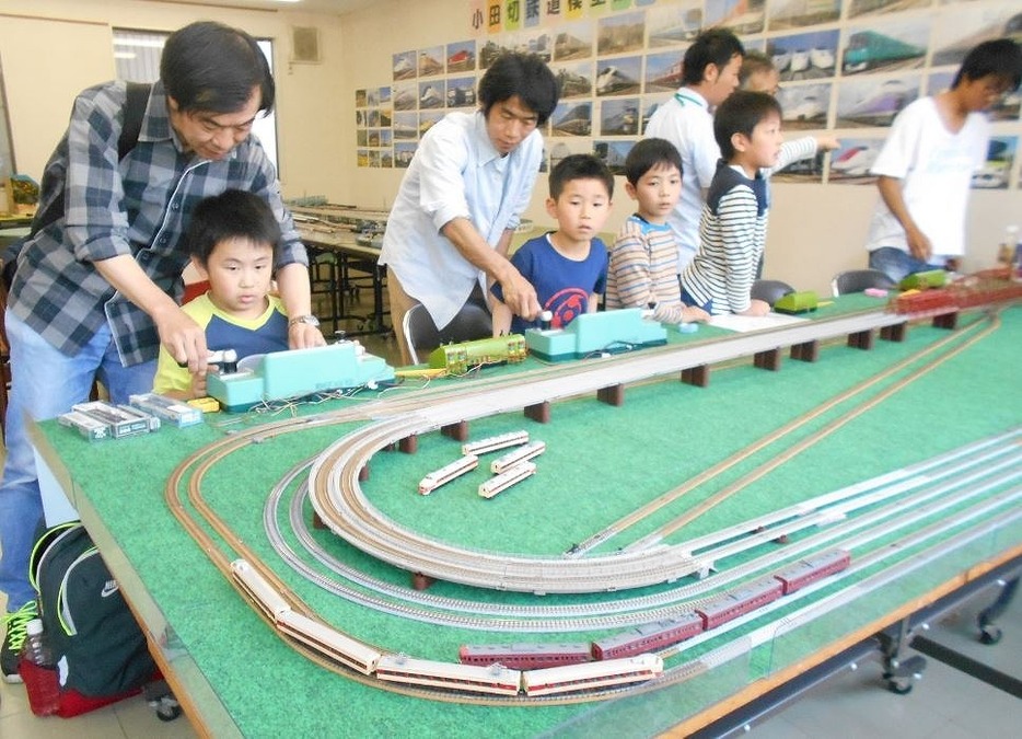 [写真]鉄道模型の運転に夢中の親子