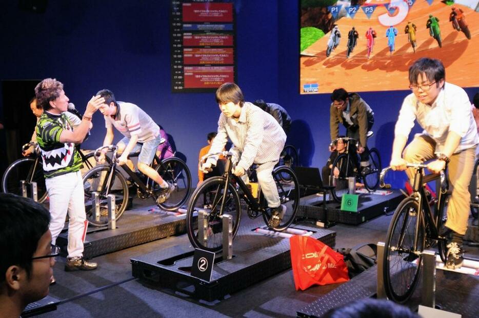 [写真]競輪のブースでは参加者同士で自転車を漕いで、レースを体験