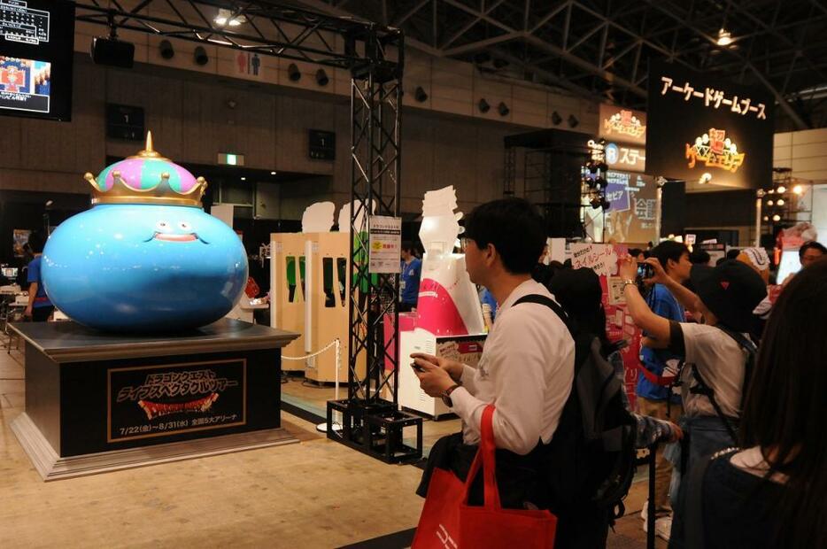 [写真]国民的テレビゲーム「ドラゴンクエスト」のキングスライムの展示を記念に撮影する人は絶えなかった