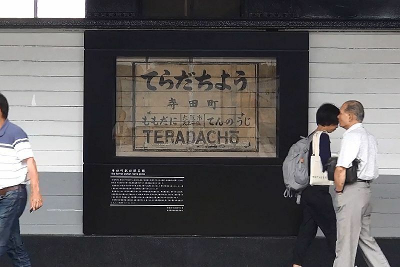 [写真]利用者が足を止め旧駅名標を見つめる姿が多く見られる＝29日正午ごろ、JR寺田町駅で