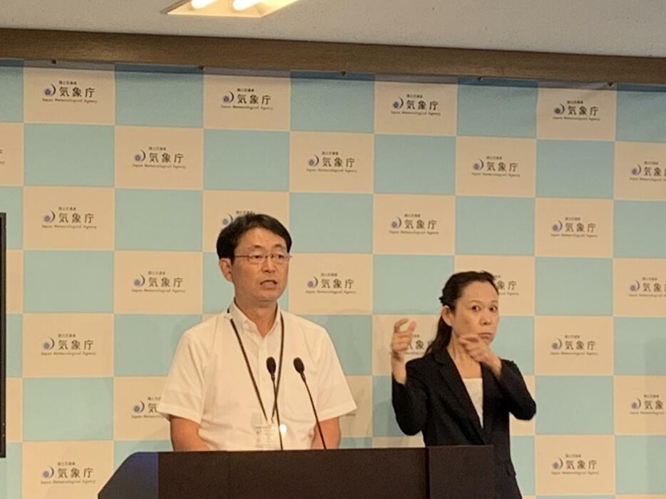 記者会見で台風15号への警戒を呼びかける中村直治予報官（左）と手話通訳者