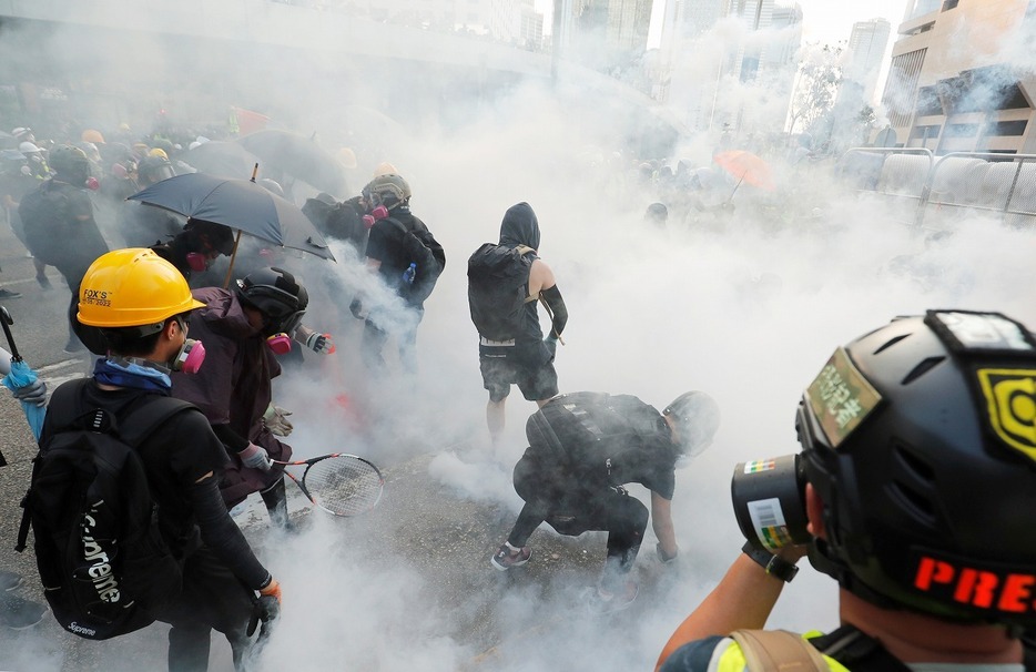 [写真]2019年9月15日、香港の中央政府施設近くのデモで、催涙ガスを浴びるデモ隊メンバー（ロイター/アフロ）