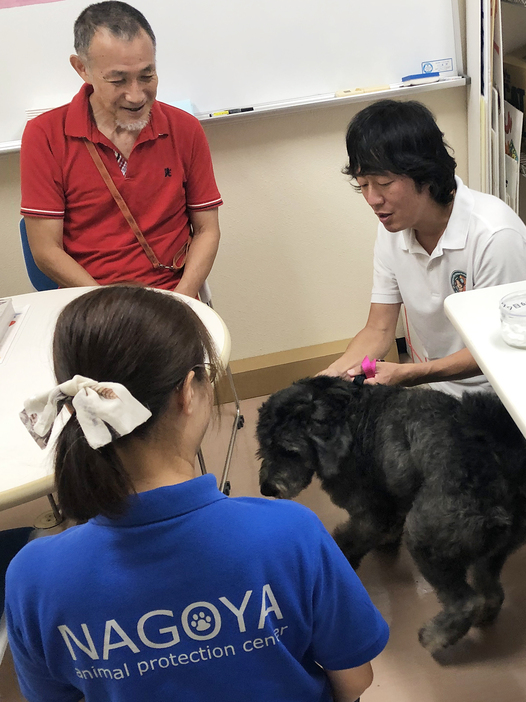 引き渡し前にセンターの職員から犬の性格や健康状態について説明を受ける鈴木嘉之さん（写真左奥）。「愛護センターとボランティアの良好な関係が殺処分ゼロに貢献しています」