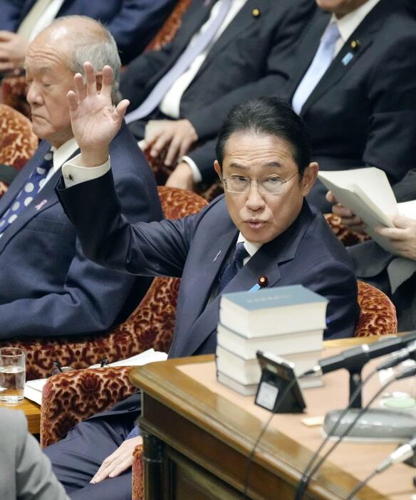 衆院予算委で答弁のため挙手する岸田首相＝24日午前