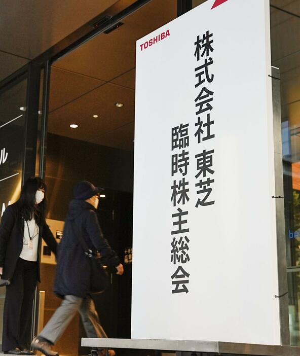 東芝の臨時株主総会会場へ向かう人たち＝22日午前、東京都新宿区