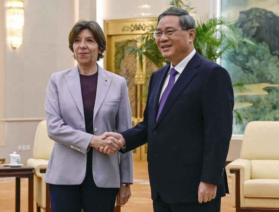 フランスのコロナ外相（左）と握手する中国の李強首相＝24日、北京の人民大会堂（AP＝共同）
