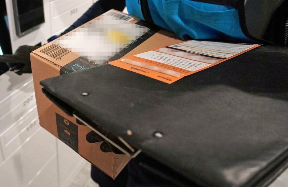 アマゾンの荷物を運ぶ岩田薫さん（仮名）＝10月、神奈川県（画像の一部を加工しています）