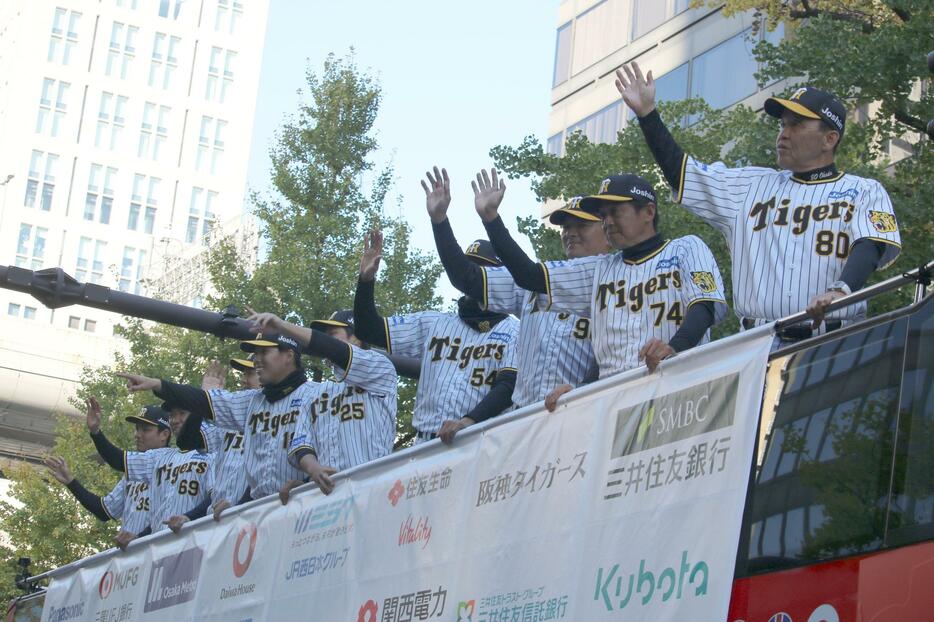 ［写真］ファンの声援に応える阪神タイガースの選手たち＝23日午後2時40分ごろ、大阪市中央区で