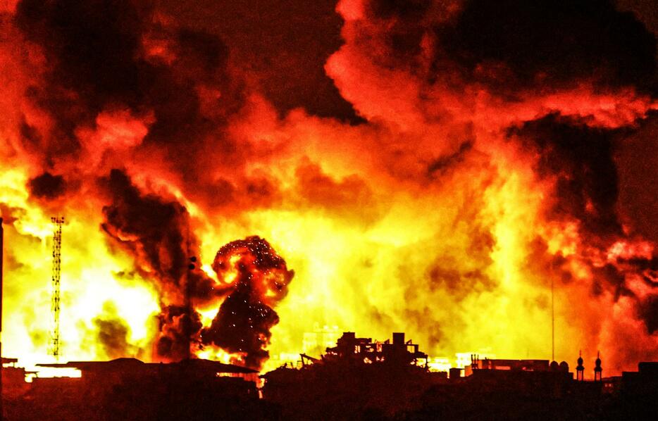 5日、イスラエル軍の攻撃で炎上するパレスチナ自治区ガザ市（ゲッティ＝共同）