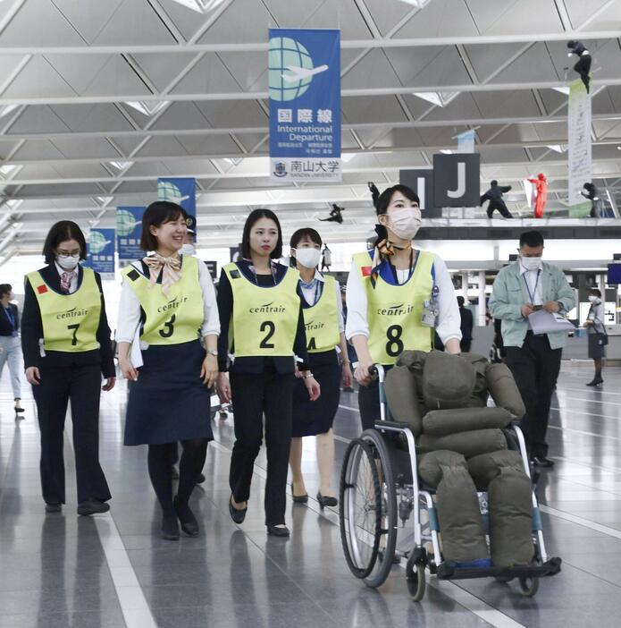 中部空港の防災訓練で、けが人を模した等身大の人形を運ぶ参加者＝28日午後、愛知県常滑市