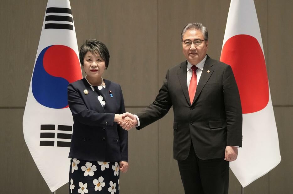 26日、韓国の朴振外相（右）と握手する上川外相＝韓国・釜山（共同）
