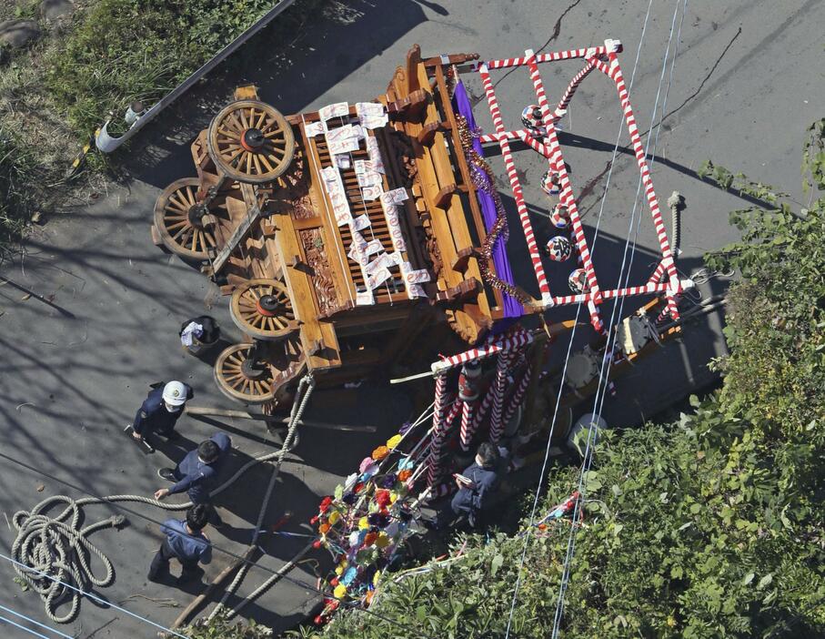 横転した祭りの山車を調べる警察官ら＝3日午前11時50分、静岡県伊豆の国市（共同通信社ヘリから）