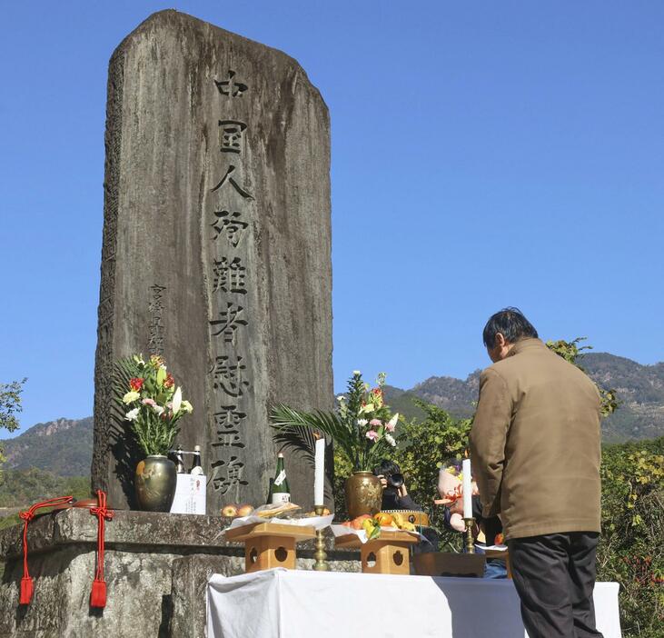 中国人慰霊碑の前で悼む遺族の肖建永さん＝21日午前、宮崎県日之影町