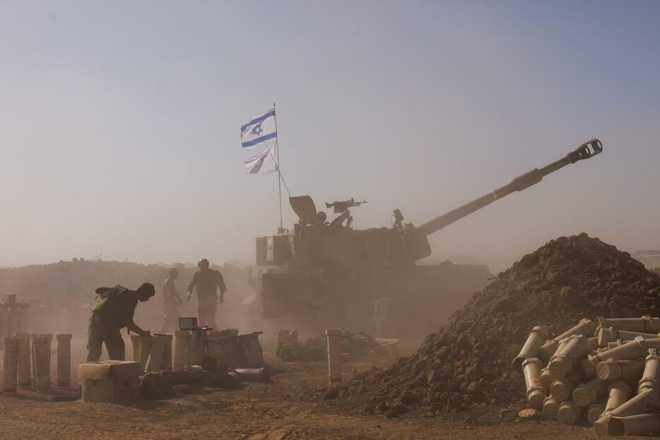6日、イスラエル南部からガザ地区に向けて砲撃するイスラエル軍（ゲッティ＝共同）