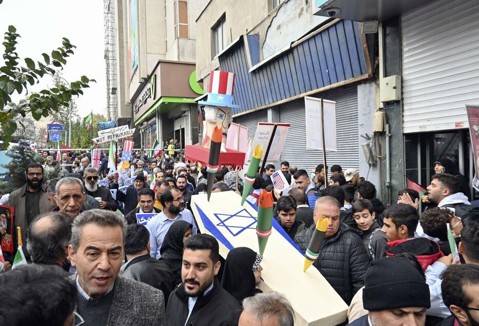 4日、イランの首都テヘランで開かれた反米集会で、イスラエル国旗を描いたひつぎを持つ人々（共同）