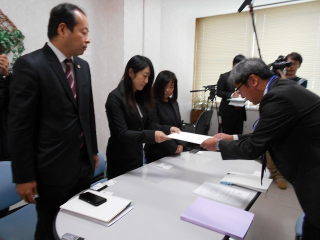 [写真]県教委に要望書を渡す母親ら（左から2人目）