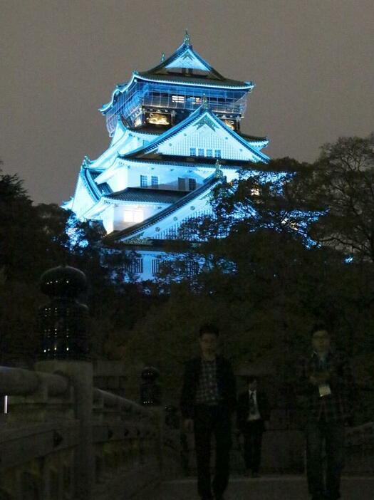 [写真]ブルーにライトアップされる大阪城=14日夜、大阪市中央区で