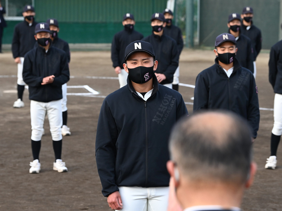 池内校長（手前）からセンバツ出場の報告を聞く河村主将（中央）ら長崎日大の選手たち＝徳野仁子撮影