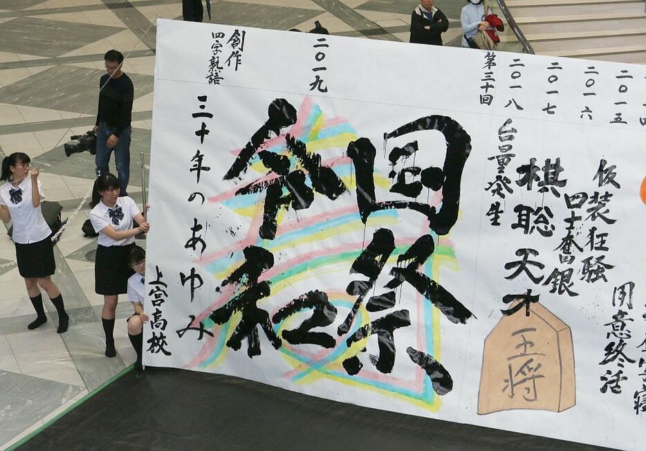 住友生命保険は17日、今年の世相を4文字で表現する「創作四字熟語」を発表。 1万9千通を超える応募の中から優秀作品に「一心桜体 （一心同体）」「国祭令和 （国際平和）」など10作品が選ばれた。同日午後には大阪市内で、書道パフォーマンスによる発表が行われた