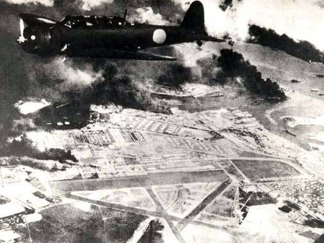 日本時間の1941年12月8日（現地時間では12月7日）、米太平洋艦隊の基地がある米・ハワイの真珠湾上空を飛ぶ日本軍の戦闘機。真珠湾は攻撃を受け、炎上している。（写真：U.S. Navy/アフロ）