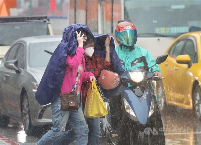 雨がっぱで上半身を覆い、早足で道を渡る歩行者ら＝資料写真