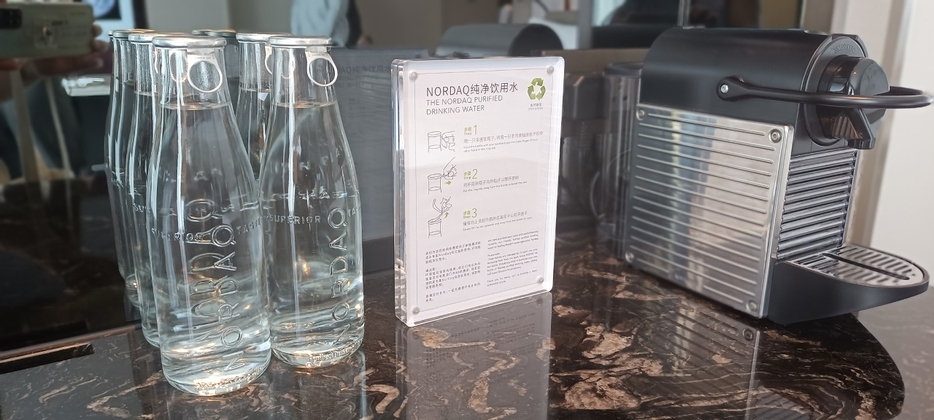 ゲストに提供する水のパッケージをペットボトルから再利用可能なガラスボトルに変更した事例（写真：DSPA）